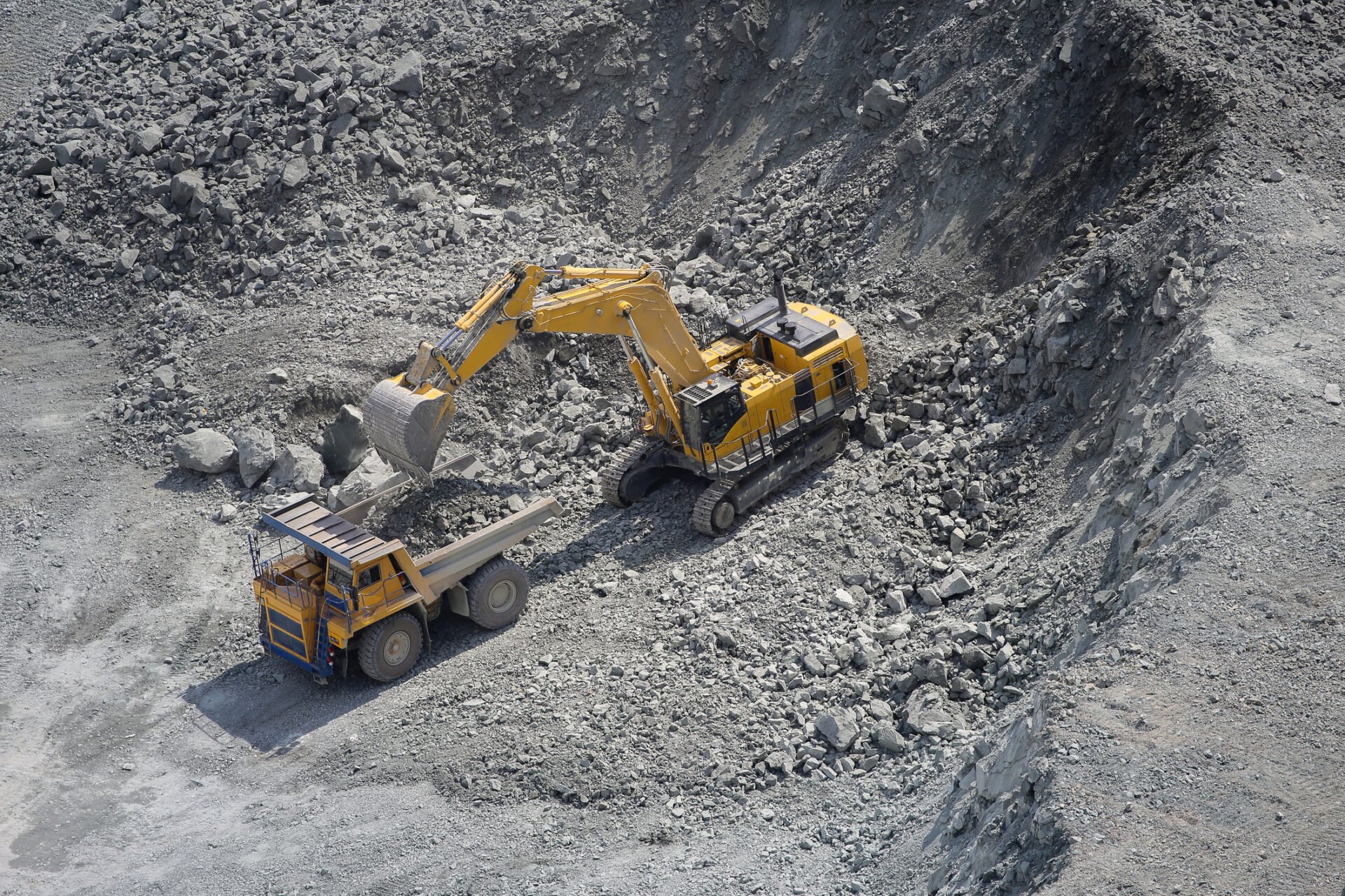 Aerial view of excavator loading ore into a mining haul truck